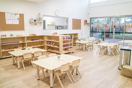 Bright Montessori classroom at Revesby Montessori Academy with activity tables and outdoor views