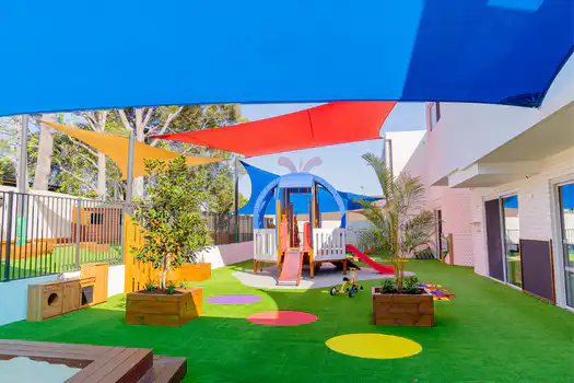 Outdoor playground at Winston Hills Montessori Academy featuring a whale climbing structure and nature-inspired play spaces.