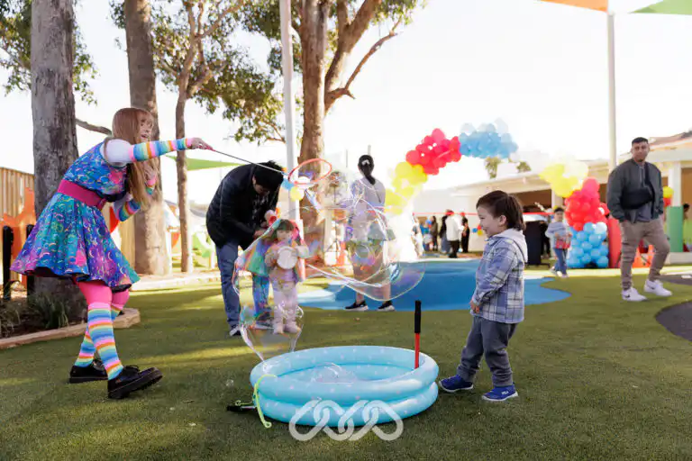 Children playing with giant bubbles at Mount Pritchard Montessori Academy.