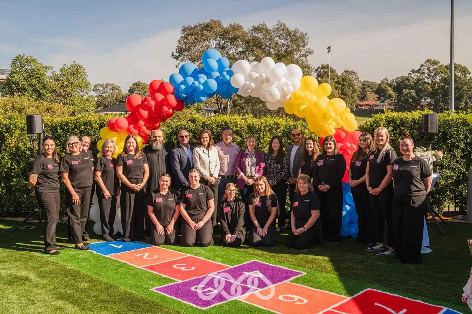 Pictured Under Balloon Arch: Father Charbel Abboud, Chief Executive Officer - Charles A, Founder & Director - Colette A, Clr Peter McClean, Sally Quinnell MP, Chief People Officer - Shelly L, Chief Operating Officer - Rami N, and Nominated Supervisor - Laura B.

