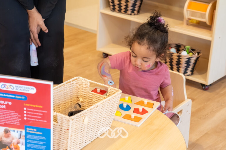 Young child concentrating on a hands-on learning activity inside Heidelberg West Montessori Academy.