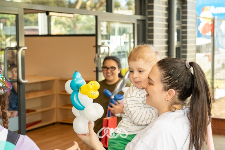 Children enjoying balloon twisting entertainment at the Heidelberg West Montessori Academy Grand Opening.