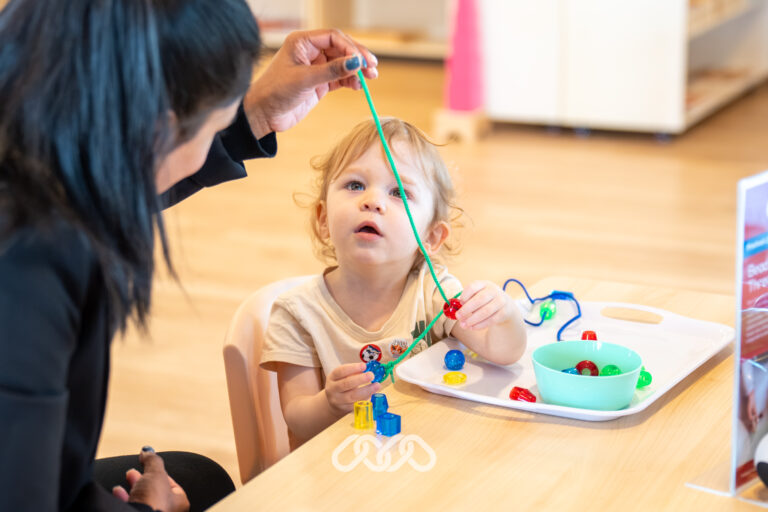 Toddler exploring colourful Montessori learning materials during the Heidelberg West Grand Opening.